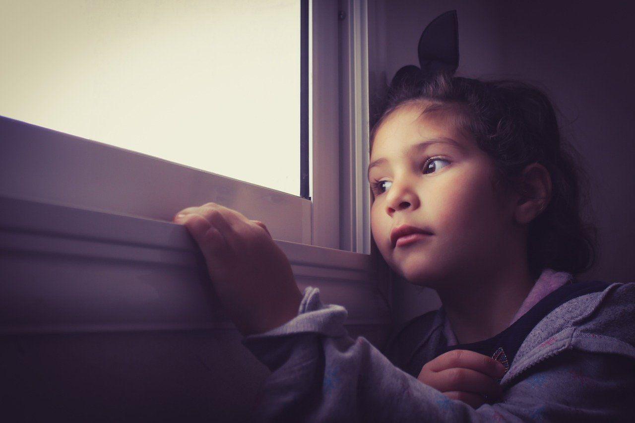 bambina triste alla finestra