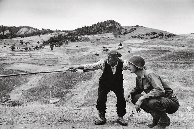 Robert Capa, Un contadino siciliano indica a un ufficiale americano la direzione presa dai tedeschi, nei pressi di Troina, 4-5 agosto 1943
